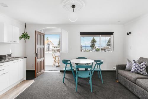 cocina y sala de estar con mesa y sillas en The Mission Belle Motel, en Mount Maunganui