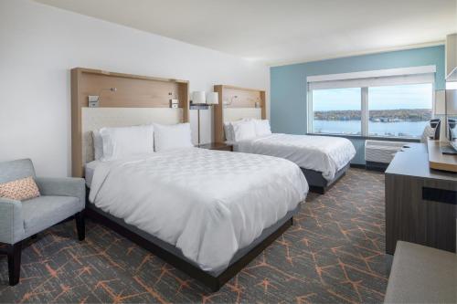 a hotel room with two beds and a chair at Holiday Inn Portland-By the Bay by IHG in Portland