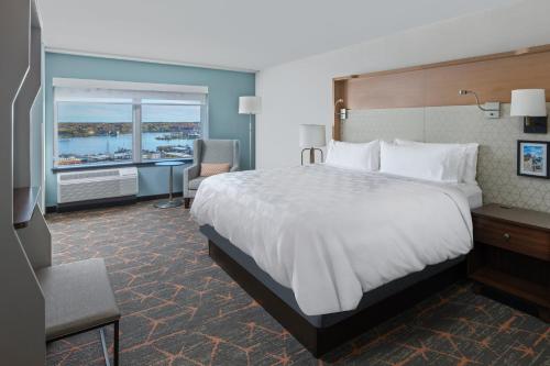 a hotel room with a large bed and a desk at Holiday Inn Portland-By the Bay by IHG in Portland