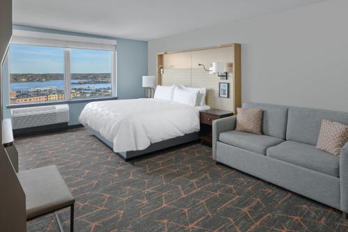 a hotel room with a bed and a couch at Holiday Inn Portland-By the Bay by IHG in Portland