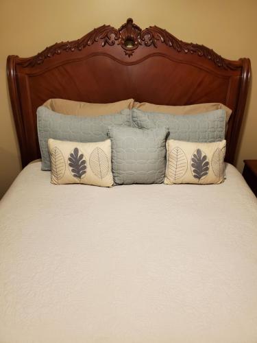 a bed with a wooden head board and pillows at Hampton House in Clinton