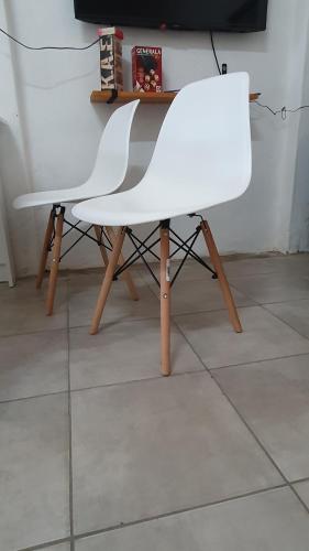 a white chair sitting on top of a tile floor at Departamento Familiar muy amplio in Concepción del Uruguay