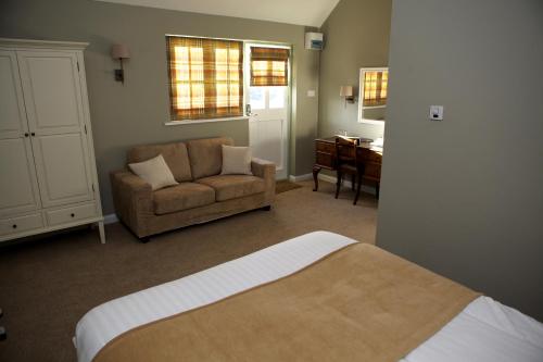 テンターデンにあるザ ブル イン ロッジズのベッドルーム1室(ベッド1台、ソファ、椅子付)