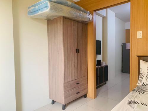 a bedroom with a bed and a wooden cabinet at Sea Residences - Property Val Alano 0995-448-8872 in Manila