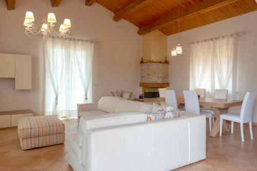 ein Wohnzimmer mit einem weißen Sofa und einem Tisch in der Unterkunft Villa Clea in Spello