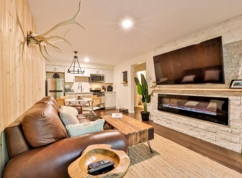 un salon avec un canapé en cuir et une cheminée dans l'établissement Cabin on Hunter Mtn Seasonal Pool Access w Panoramic Views Hike Swim Fish Relax, à Lanesville