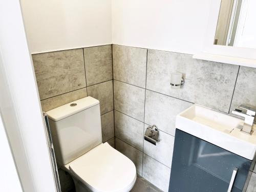 ein Badezimmer mit einem weißen WC und einem Waschbecken in der Unterkunft Minet Gardens - Centrally located Apartment - Rm 1 in London