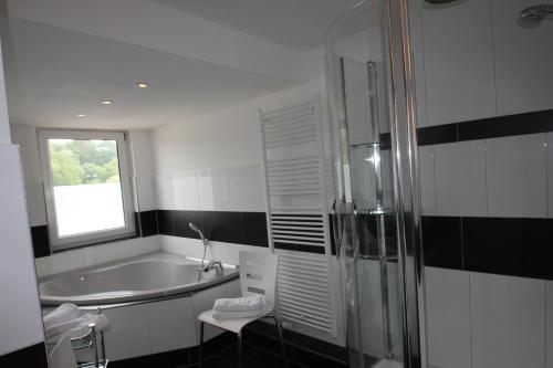 a bathroom with a tub and a sink and a window at Haus Godewind in Binz