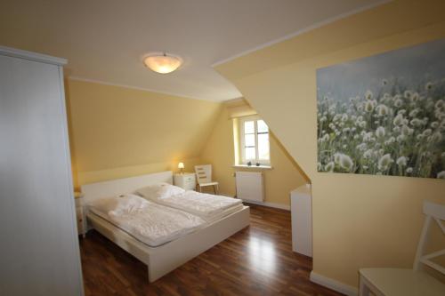 a bedroom with a bed and a painting on the wall at Haus Godewind in Binz