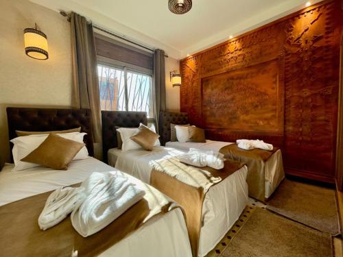 a hotel room with two beds with towels on them at Hotel Apartments Lexpert " Riad The Family" in Merzouga