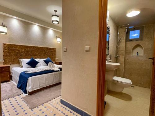 una camera con letto e un bagno con servizi igienici di Hotel Apartments Lexpert a Merzouga