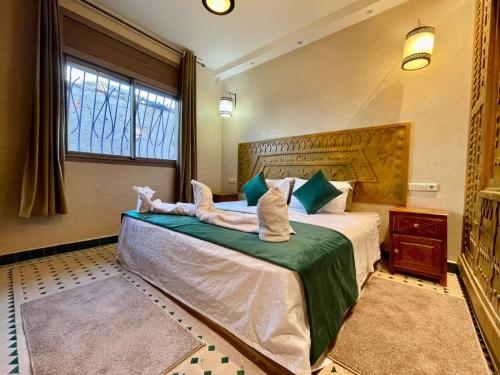 una camera da letto con un grande letto con asciugamani di Hotel Apartments Lexpert a Merzouga