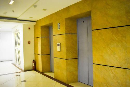 a hallway with yellow walls and a door at The Boni Tower by RSPL Manila City Center in Manila
