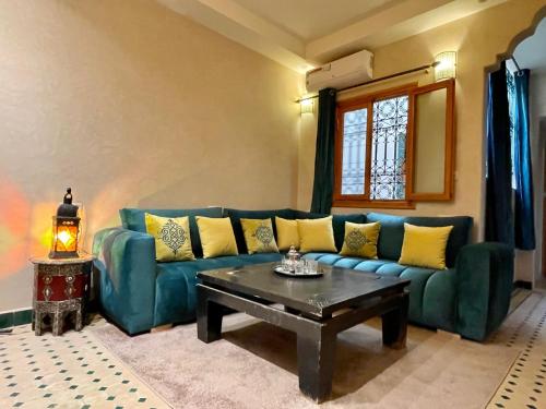 a living room with a blue couch and a coffee table at Hotel Apartments Lexpert " Riad The Family" in Merzouga