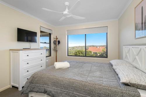 a bedroom with a bed and a large window at Pacific 1 in Port Macquarie