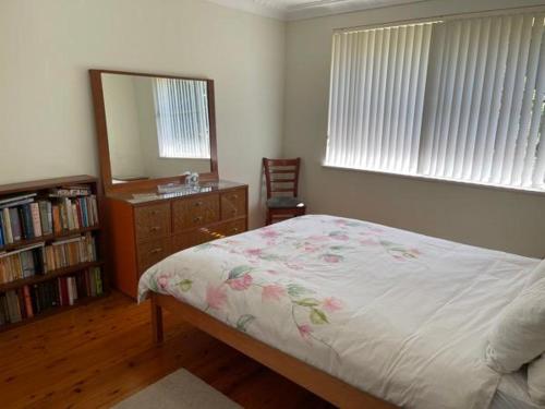 a bedroom with a bed and a dresser and a mirror at Laurel 14 in Port Macquarie