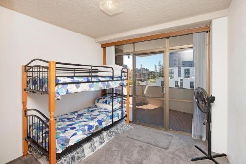 ポート・マッコリーにあるFountain Court 19の二段ベッドが2つと窓のある部屋
