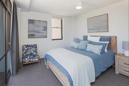- une chambre avec un lit bleu et une chaise dans l'établissement Tasman 15, à Port Macquarie