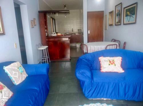 uma sala de estar com um sofá azul e uma cozinha em Frente ao Mar Del Plata em São Vicente