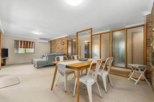 a dining room with a table and chairs and a couch at Talga 5 in Port Macquarie