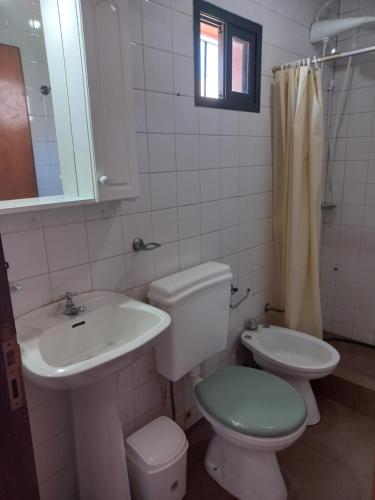 y baño con lavabo, aseo y espejo. en Departamento Céntrico en Posadas