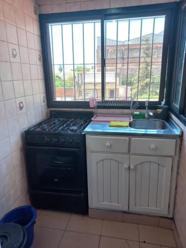 cocina con fogones, fregadero y ventana en Departamento Céntrico en Posadas