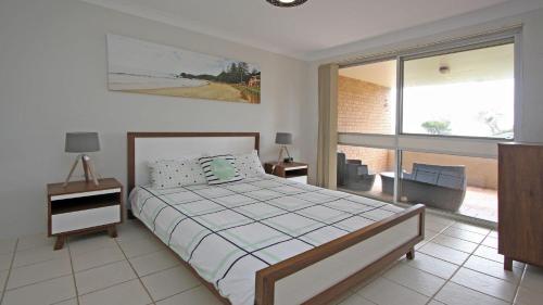 ein Schlafzimmer mit einem Bett und einem großen Fenster in der Unterkunft Flynns View 8 in Port Macquarie