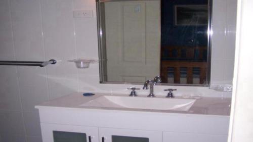 Un baño con un lavabo blanco y un espejo. en Forster Lodge 10, en Forster
