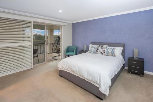 - une chambre avec un grand lit et un balcon dans l'établissement 22 The Promenade, à Port Macquarie