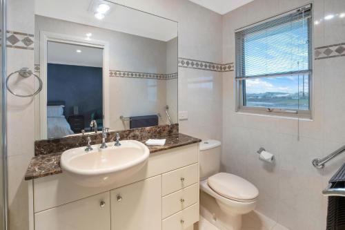 baño con lavabo y aseo y ventana en 22 The Promenade, en Port Macquarie