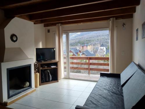 uma sala de estar com lareira e uma grande janela em Villa Catedral em San Carlos de Bariloche