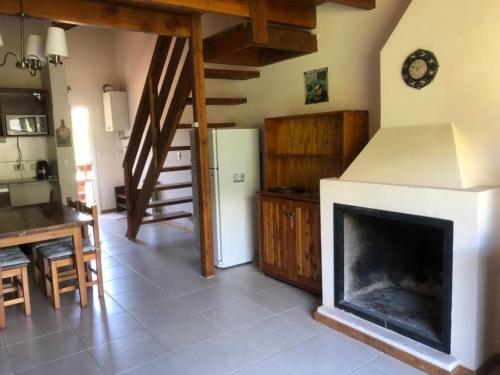 a living room with a fireplace and a kitchen at Villa Catedral in San Carlos de Bariloche