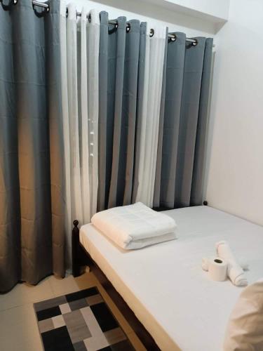 a room with a bed with blue curtains at Sea Residences Tower F Angel in Manila