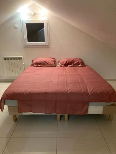 - un lit avec une couette rouge dans l'établissement Superbe appartement parking gratuit 2, à Aulnay-sous-Bois
