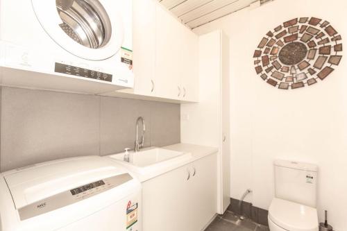 ein weißes Bad mit einem Waschbecken und einem WC in der Unterkunft Eliza Lee 2 50 Gippsland Street in Jindabyne