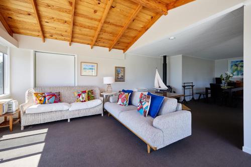 a living room with two couches and a table at Views on Scarborough in Kaikoura