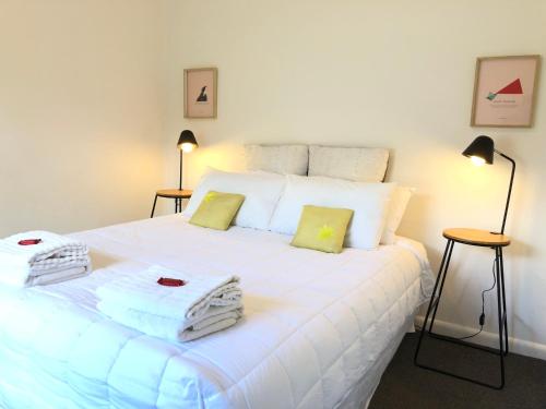 1 dormitorio con 1 cama blanca grande y toallas. en Comfy at Ed's - 20 mins to Kaiteri & Abel Tasman en Motueka