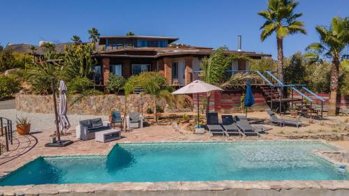 une maison avec une piscine en face d'une maison dans l'établissement Rancho Cien Piedras, à Valle de Guadalupe