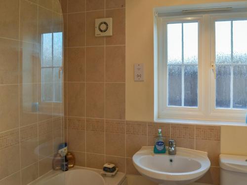 a bathroom with a sink and a tub and a toilet at Autumn Lodge in Mablethorpe