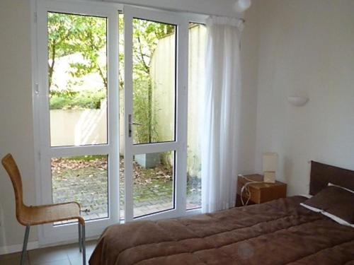 een slaapkamer met een bed en een groot raam bij Appartement Pyla-sur-Mer, 2 pièces, 4 personnes - FR-1-420-47 in Pyla-sur-Mer