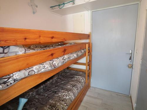 ein Paar Etagenbetten in einem Zimmer mit einer Tür in der Unterkunft Studio Le Grau-du-Roi, 1 pièce, 4 personnes - FR-1-307-96 in Le Grau-du-Roi