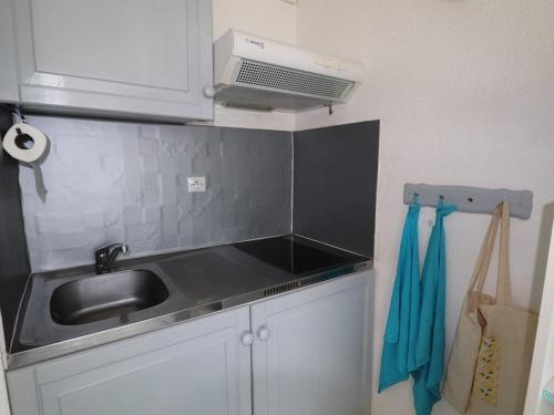 eine Küche mit einer Spüle und einer Mikrowelle in der Unterkunft Studio Le Grau-du-Roi, 1 pièce, 4 personnes - FR-1-307-96 in Le Grau-du-Roi