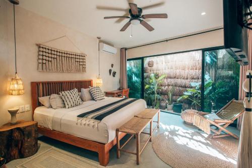 a bedroom with a bed and a ceiling fan at Vida Boho Apart 3 with special fee to access Hotel Bardo in Tulum