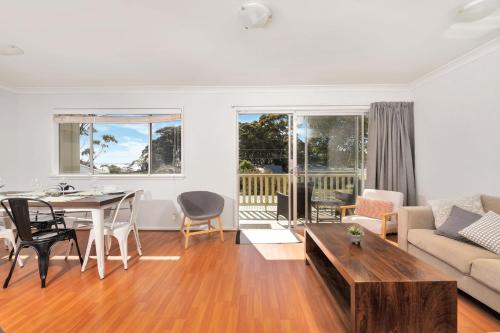 a living room with a table and a couch at Lilli Pilli House by Experience Jervis Bay in Vincentia