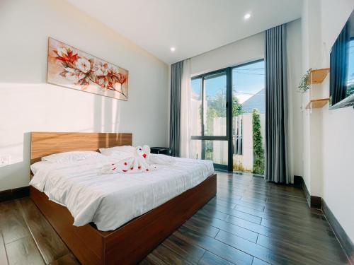 a bedroom with a large bed and a large window at Mia Homestay in Hoi An