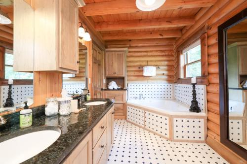 a bathroom with two sinks and a tub at Rustic Cabin with seasonal Pool & Fire Pit - close to to Bike Path in Celina