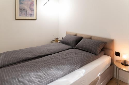 ein Bett mit zwei Kissen darauf in einem Schlafzimmer in der Unterkunft Deluxe Dunavska Apartment 3 in Novi Sad