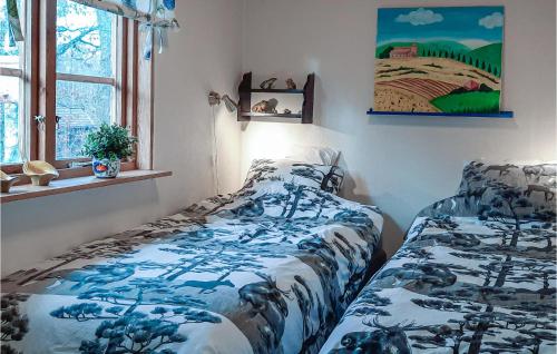 a bedroom with a bed with a blue and white blanket at Lovely Home In Rke With Wifi in Röke
