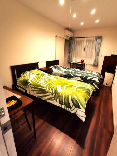 a bedroom with two beds and a wooden floor at Bell house in Tokyo