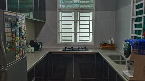 uma cozinha com um lavatório e um frigorífico em illa Bella Homestay Jasin em Jasin